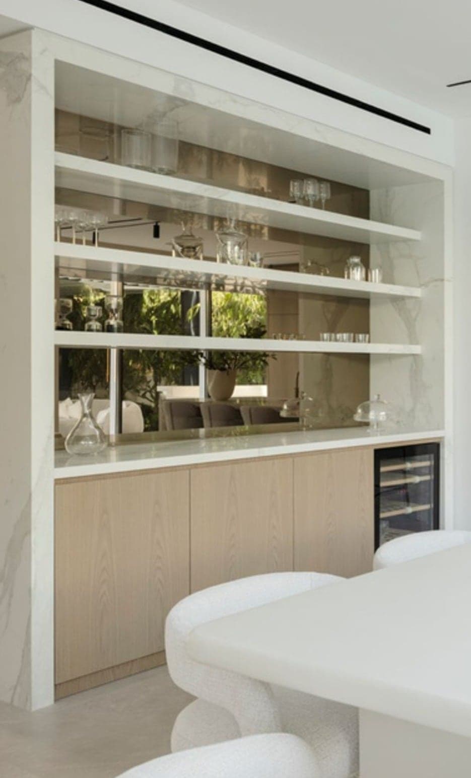 Mirrored back bar with glass shelving, marble surround and wine storage