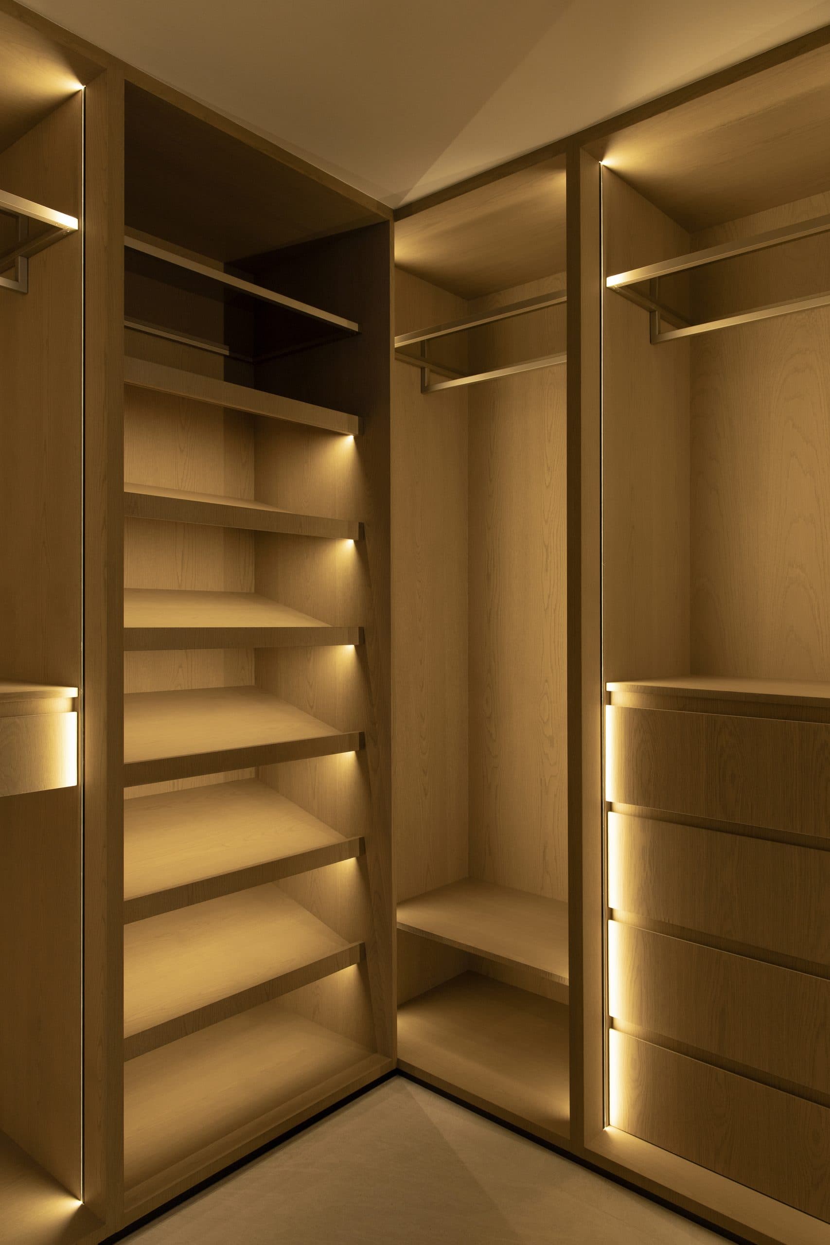 Corner wardrobe in oak with strip lighting along every shelf