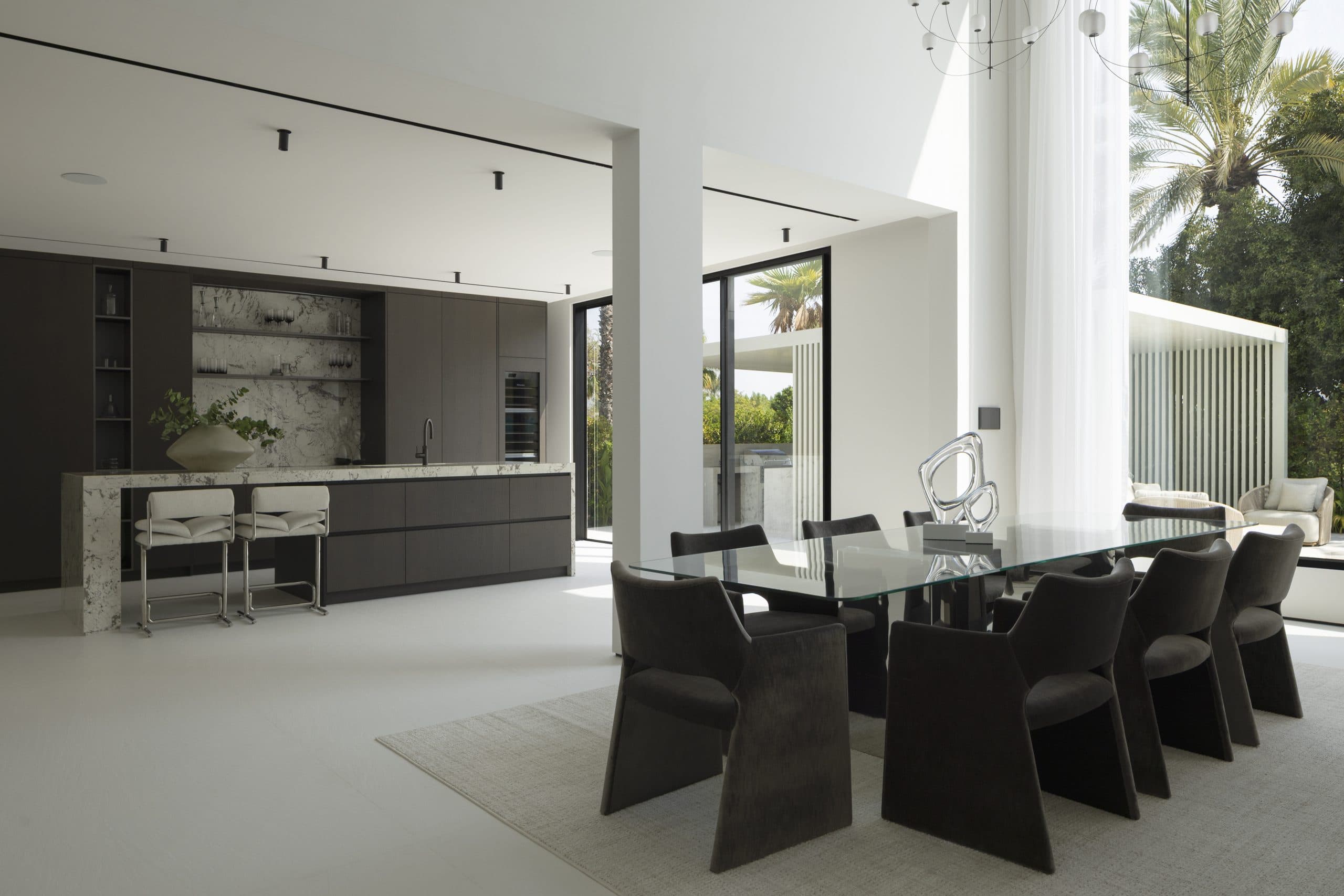 Open-plan kitchen and dining space with dark oak cabinetry and a marble island