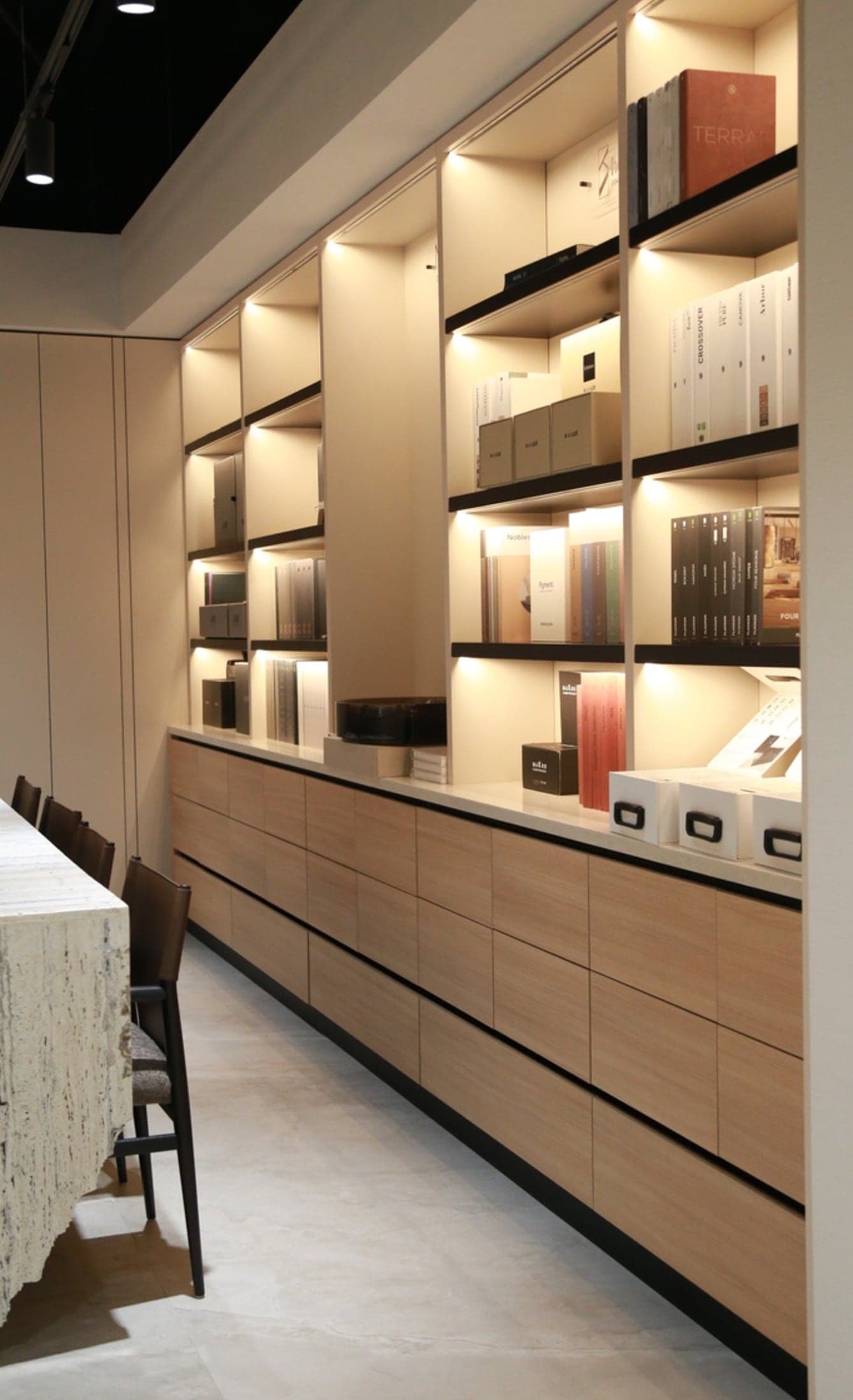 Retail interior with a full-height lit display wall and a long timber service counter