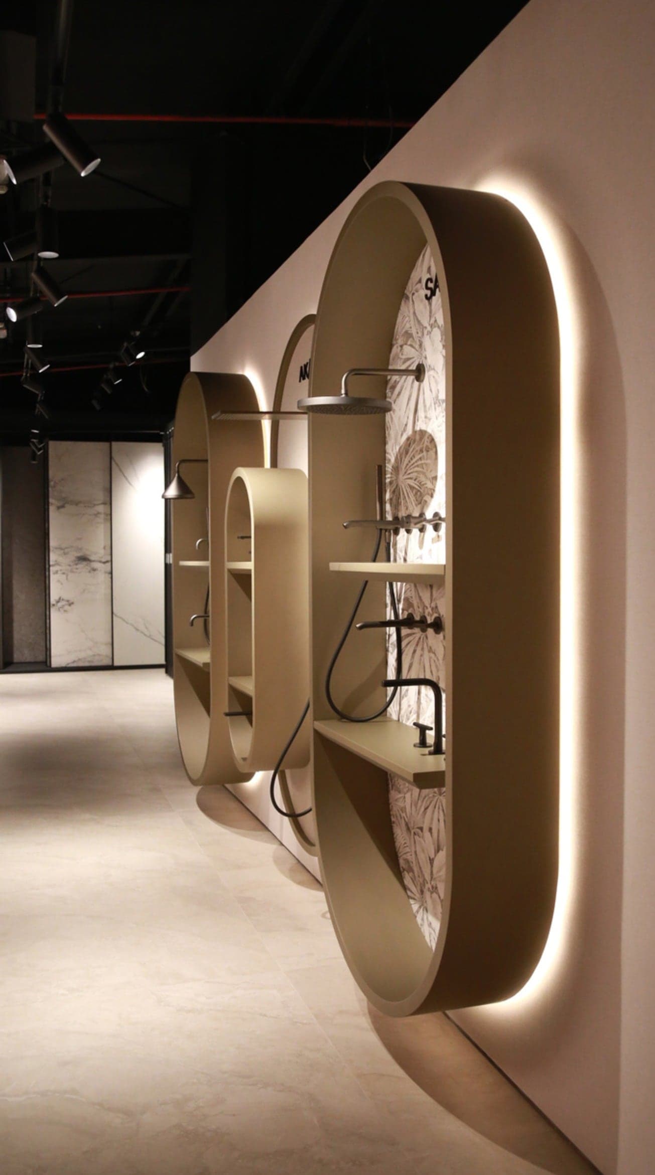 Curved metal-framed display units with integrated lighting in a retail interior