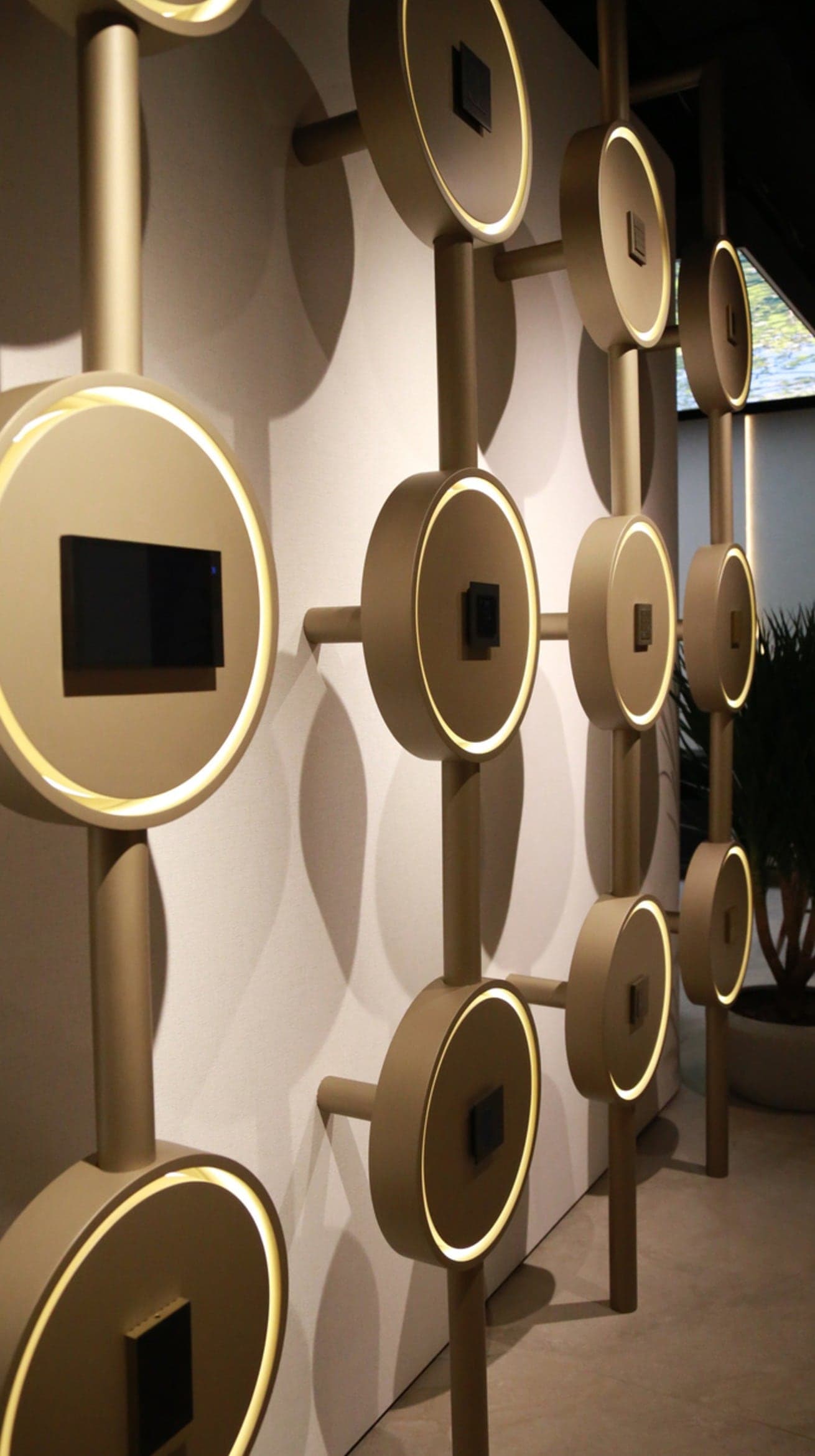 Detail of circular metal display rings mounted on a sculpted wall