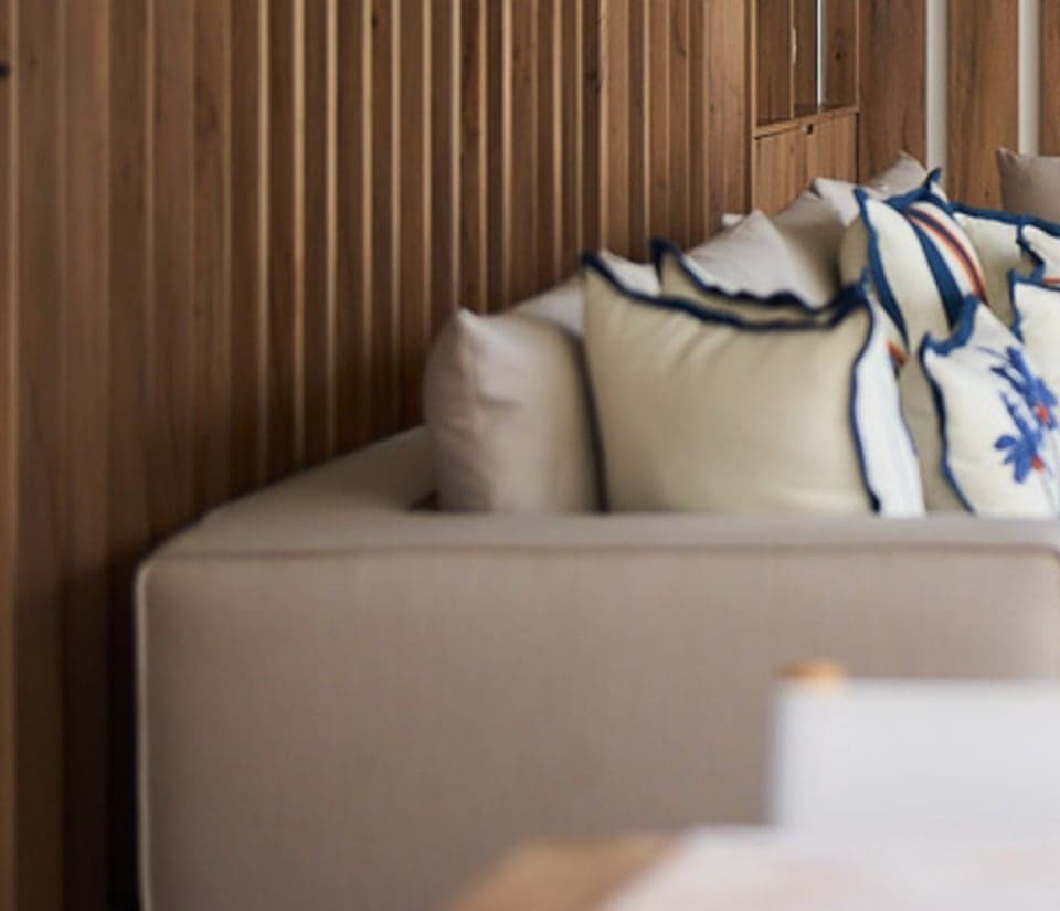 Close-up of oak slat panelling behind a low sofa