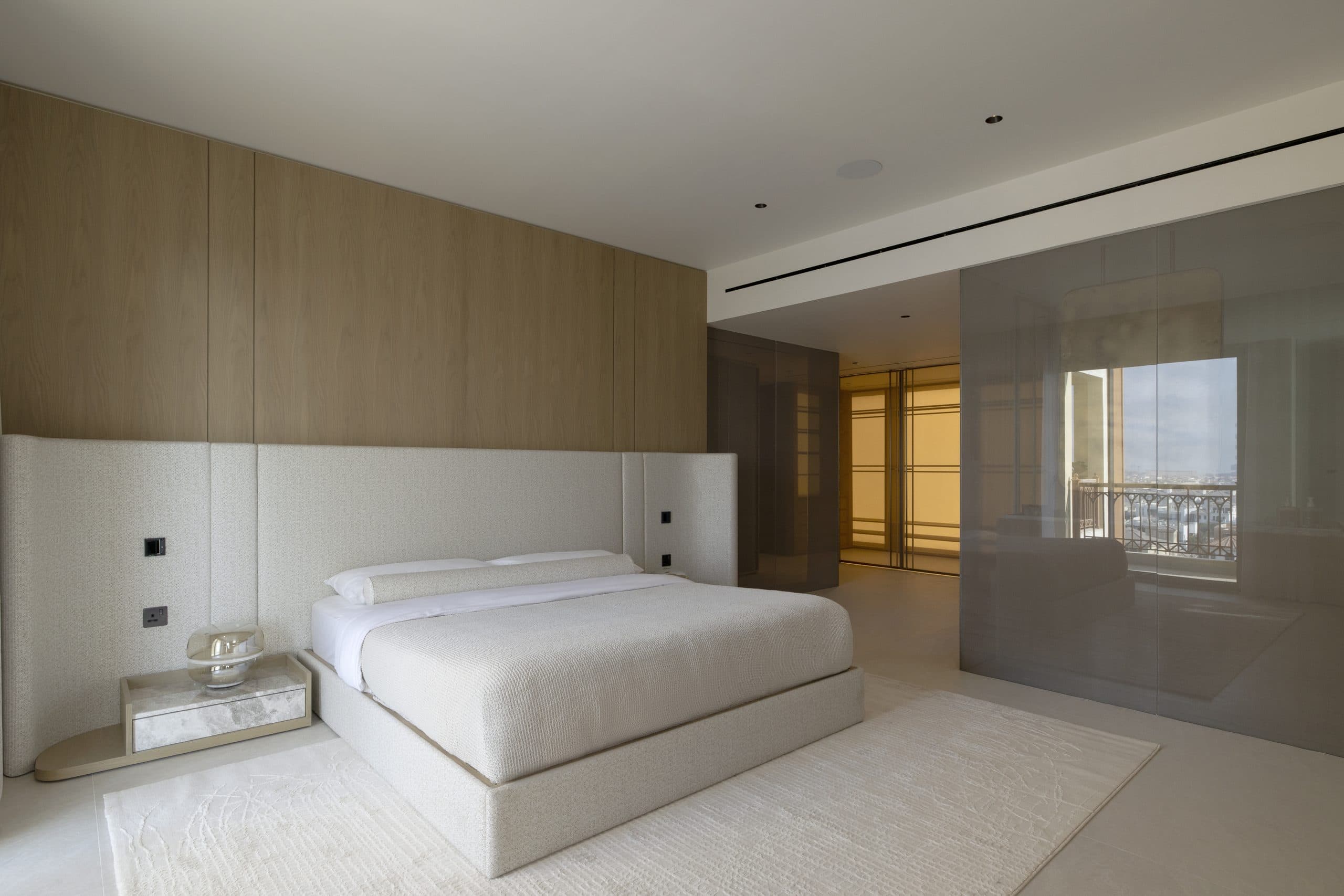 Master bedroom with an oak panelled headwall and a wide upholstered headboard